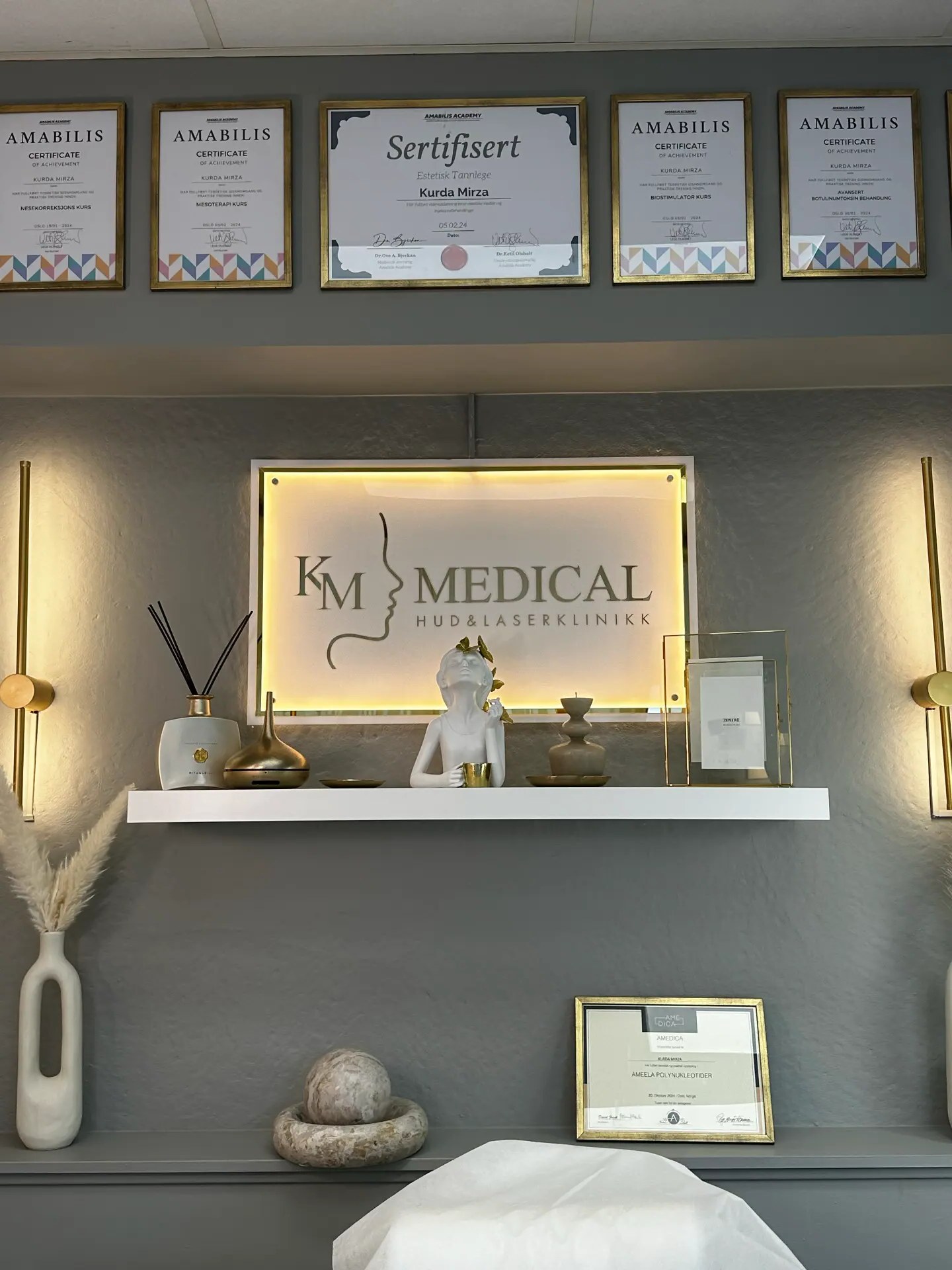 Sertifikater og diplomer på veggen hos KM Medical